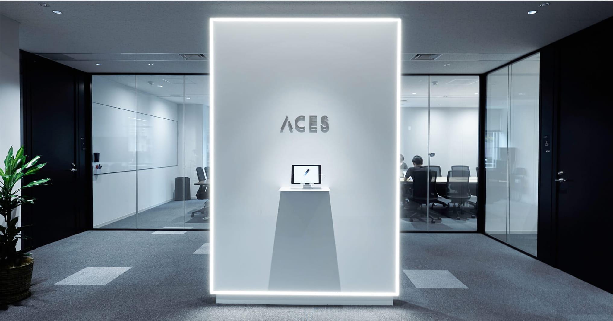 写真：近未来的な雰囲気のオフィスの入り口。ACESと書かれた看板が中央に見える。